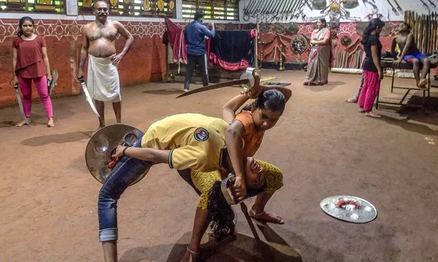 This picture taken on September 14, 2021 shows Sajeev Kumar (top 2L) practitioner and teacher of “Kalaripayattu”, a traditional martial art originated in Kerala, training students at his family-run Kadathanadan Kalari Sangam school in Vatakara in the Kozhikode district of the state of Kerala. (Photo by Manjunath Kiran/AFP Photo)