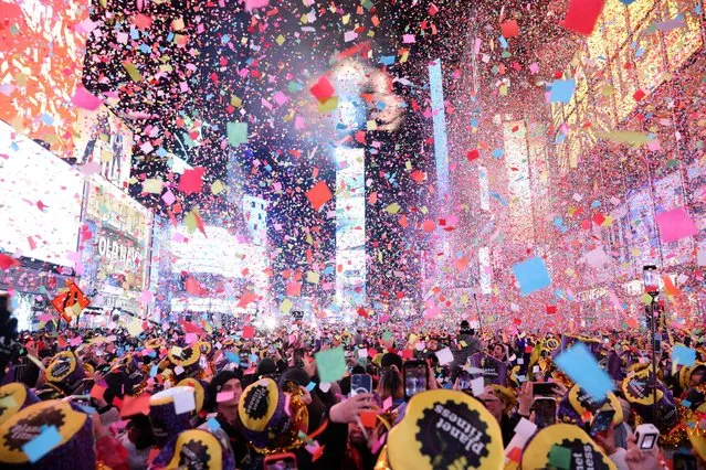 Confetti flies around the countdown clock during the first public New Year's event since the coronavirus disease (COVID-19) pandemic, at Times Square, in the Manhattan borough of New York City, New York, U.S., January 1, 2023. (Photo by Andrew Kelly/Reuters)