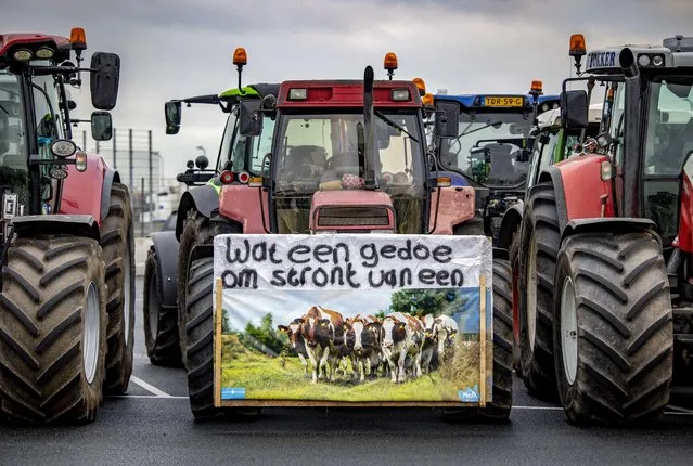 Farmers gather with tractors in Rozenburg near Schiphol Airport, the Netherlands, 13 December 2021, to offer the airport a buyout contract. Amid government plans to cut nitrogen pollution by buying out farmers and reducing agricultural production, the convoy travelled to Schiphol to deliver a contract to buy out and decommission the airport, equally responsible for pollution, according to the farmers. (Photo by Ramon van Flymen/EPA/EFE)