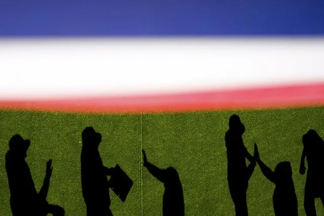 Boston Red Sox pitchers and staff cast shadows as they high-five in the bullpen before a baseball game against the Seattle Mariners, Sunday, March 31, 2024, in Seattle. (Photo by Lindsey Wasson/AP Photo)