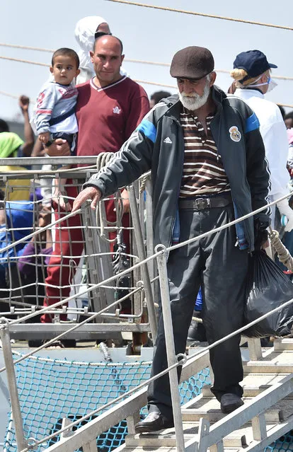 Migrants disembark from the Irish Navy ship P31 L.E. Eithne at the Catania harbor, Italy, Tuesday, June 16, 2015. European Union nations failed to bridge differences Tuesday over an emergency plan to share the burden of the thousands of refugees crossing the Mediterranean, while on the French-Italian border, police in riot gear forcibly removed dozens of migrants. (AP Photo/Carmelo Imbesi)