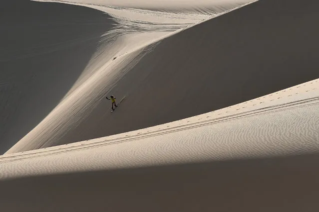 This photograph taken on April 24, 2019 shows Nguyen Thai Binh riding down sand dunes on his snowboard in the southern Vietnamese town of Mui Ne. Sun-kissed and shaggy haired, Nguyen Thai Binh swaps his flip flops for bulky boots ahead of snowboarding practice on the sand dunes of southern Vietnam – the unlikely training ground for the country's fledgling winter athletes with mountain-sized ambitions. (Photo by Manan Vatsyayana/AFP Photo)