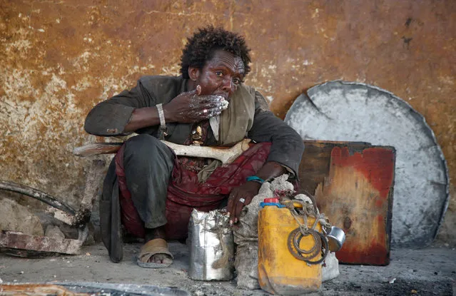 An internally displaced Somali man eats a maize meal from the United Nations World Food Programme (WFP) feeding program at the Sorrdo camp in Hodan district of Somalia's capital Mogadishu, March 11, 2017. (Photo by Feisal Omar/Reuters)