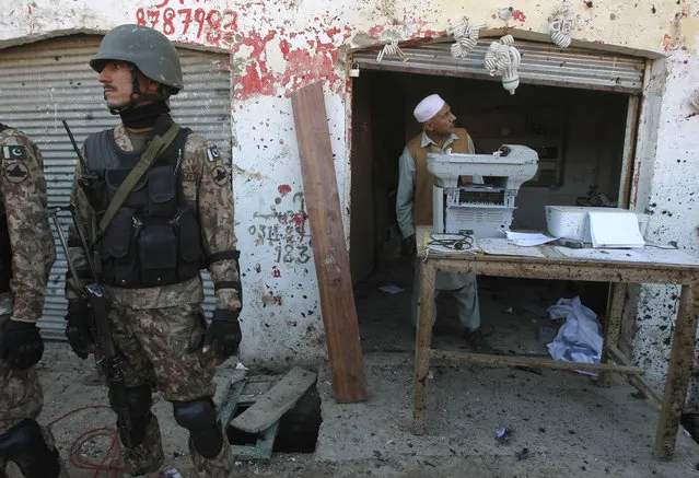 Pakistani soldiers stand alert outside a courthouse following suicide bombing in Charsadda, Pakistan, Tuesday, February 21, 2017. Police say three suicide bombers have attacked a courthouse in northwestern Pakistan. Charsadda police chief says one of the bombers detonated his suicide vest at the court's main gate while police shot and killed the two other assailants. (Photo by Mohammad Sajjad/AP Photo)