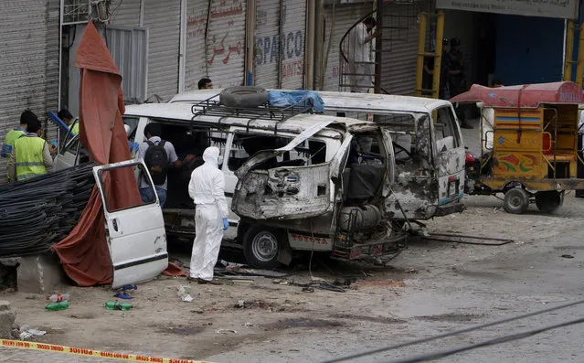 Pakistani investigators examine damage vehicles at the site of suicide bombing in Lahore, Pakistan, Wednesday, April 5, 2017. A suicide bomber detonated his explosives near a vehicle carrying census workers in eastern Pakistan on Wednesday, killing six people, two data collectors and four soldiers who were escorting them, a government spokesman and police said. (Photo by K.M. Chaudary/AP Photo)