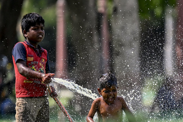 Children play with water during a hot summer day amid severe heatwave in New Delhi on May 31, 2024. Extreme temperatures across India are having their worst impact in the country's teeming megacities, experts said on May 30, warning that the heat is fast becoming a public health crisis. India is enduring a crushing heatwave with temperatures in several cities sizzling well above 45 degrees Celsius (104 degrees Fahrenheit). (Photo by Money Sharma/AFP Photo)