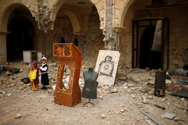 Boys visit the burnt out main church as Iraqis attend the first Palm Sunday procession in the Christian city of Qaraqosh since Iraqi forces retook it from Islamic States militants, Iraq April 9, 2017. (Photo by Suhaib  Salem/Reuters)