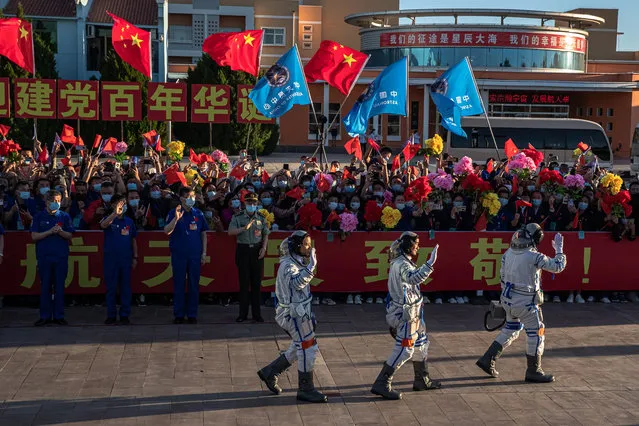 Chinese astronauts Tang Hongbo, Nie Haisheng, and Liu Boming wave during a departure ceremony before the launch of the Long March-2F carrier rocket, carrying the Shenzhou-12 at the Jiuquan Satellite Launch Center, in the Gobi Desert, northwest of China, 17 June 2021. China launches Shenzhou-12 spacecraft carrying three crew members Tang Hongbo, Nie Haisheng, and Liu Boming to the orbiting Tianhe core module for a three-month mission on 17 June. It is the first spaceflight in almost five years where China sends humans into space. (Photo by Roman Pilipey/EPA/EFE)