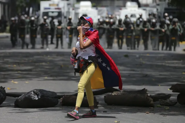 A demonstrator walks along a barricade set up during opposition protesters in Caracas, Venezuela, Wednesday, April 19, 2017. (Photo by Fernando Llano/AP Photo)