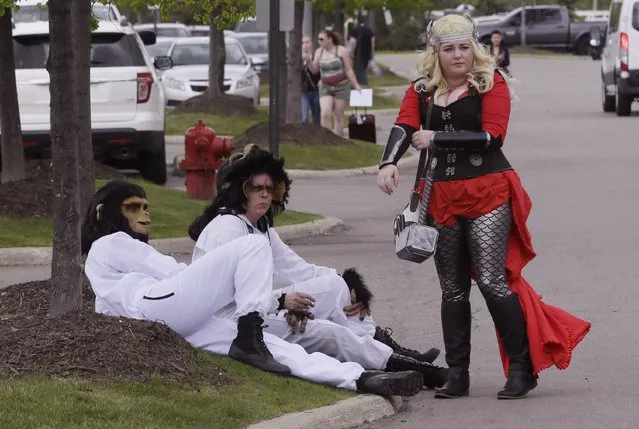 From left, Sean Baumgartner as Cornelius and Rhonda Payne as Caesar from Planet of the Apes, and Katey Griffin as Thor, take a break outside the Motor City Comic Con, Friday, May 13, 2016 in Novi, Mich. (Photo by Carlos Osorio/AP Photo)