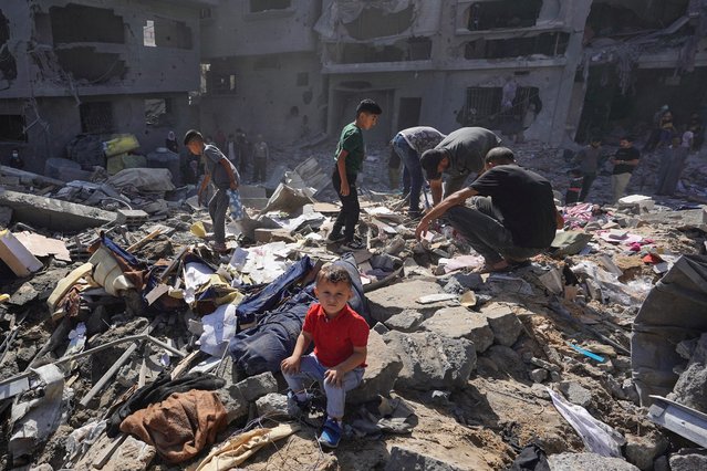 A Palestinian boy sits as people search the rubble of the Harb family home destroyed in overnight Israeli strikes in al-Bureij refugee camp in the central Gaza Strip, on June 18, 2024, amid the ongoing conflict between Israel and the Palestinian militant Hamas movement. (Photo by Bashar Taleb/AFP Photo)