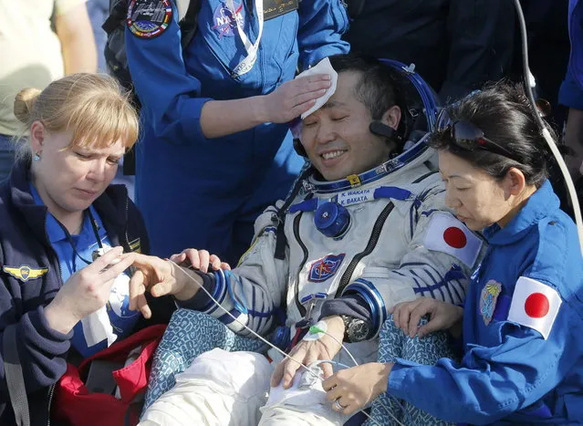 Russian, Japanese and NASA specialists help Japanese astronaut Koichi Wakata shortly after the Russian Soyuz TMA-11M space capsule landed south-east of town Dzhezkazgan,  Kazakhstan, May 14, 2014. A Soyuz space capsule with Japanese astronaut Koichi Wakata, Russian cosmonaut Mikhail Tyurin and U.S. astronaut Rick Mastracchio, returning from a five-month mission to the International Space Station, landed safely Wednesday on the steppes of Kazakhstan. (Photo by Dmitry Lovetsky/Reuters)