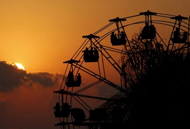 People ride a Ferris wheel in an amusement park as they celebrate tthe first day of the Muslim holiday of Eid al-Fitr, which marks the end of the holy month of Ramadan at the port-city of Sidon, southern Lebanon July 17, 2015. (Photo by Ali Hashisho/Reuters)