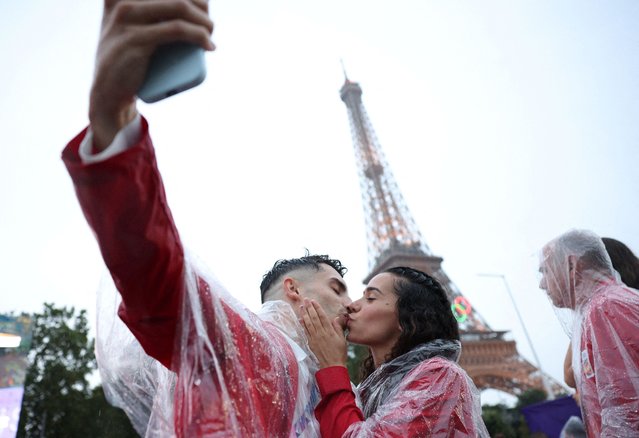 Spanish athletes take a selfie while kissing under the Eiffel Tower during the opening ceremony in Paris, France on July 26, 2024. (Photo by Violeta Santos Moura/Reuters)