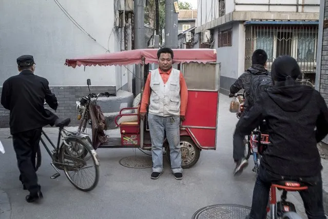 This photo taken on April 22, 2017 shows a rickshaw driver (C) posing in Beijing. (Photo by Fred Dufour/AFP Photo)