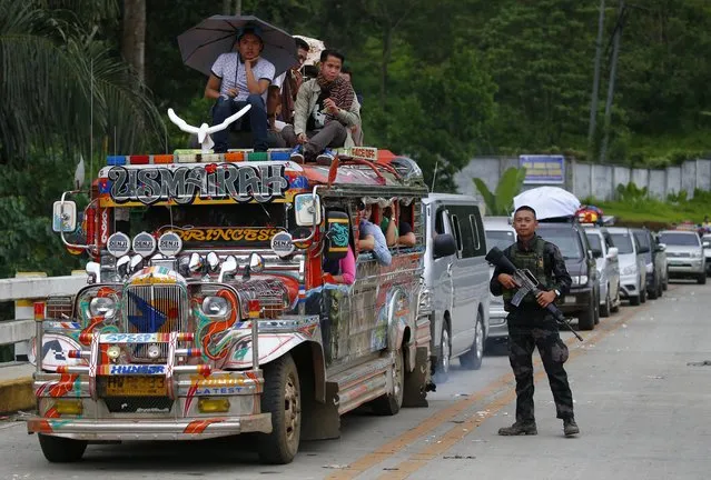 Fleeing residents wait for their turn to be inspected by police as they flee Marawi city Thursday, May 25, 2017 in southern Philippines. (Photo by Bullit Marquez/AP Photo)