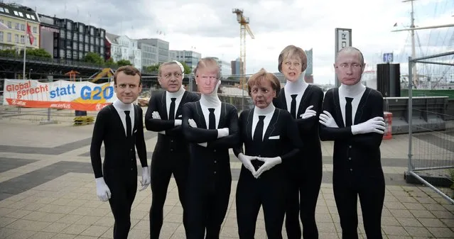 Activists of the “Attac” network wear masks of (L-R) French President Emmanuel Macron, Turkish President Recep Tayyip Erdogan, US President Donald Trump, German Chancellor Angela Merkel, Britain's Prime Minister Theresa May and Russian President Vladimir Putin as they demonstrate on July 4, 2017 in Hamburg, northern Germany, ahead of a two-day Group of 20 summit. More than 30 demonstrations have been scheduled in the days before and during the two-day G20 meeting that starts Friday, July 7, 2017, guarded by almost 20,000 police. (Photo by Daniel Reinhardt/AFP Photo/DPA)