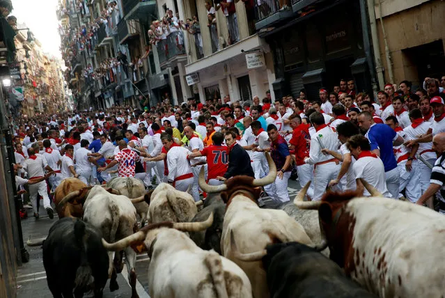 Runners sprint ahead of bulls during the first running of the bulls at the San Fermin festival in Pamplona, northern Spain, July 7, 2017. (Photo by Susana Vera/Reuters)