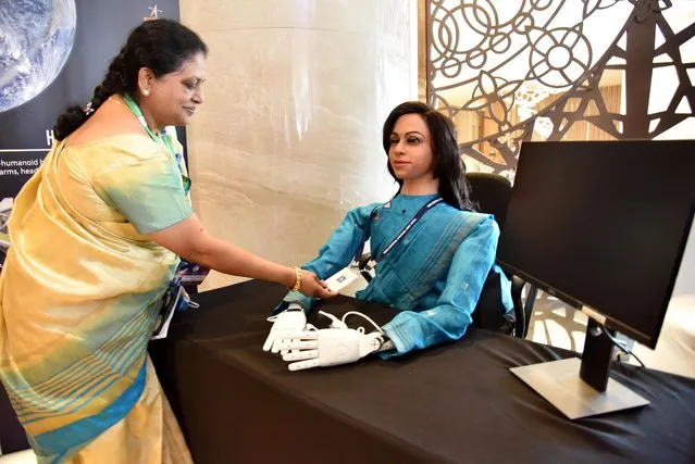 A woman checks an identity card of Vyommitra, a humanoid developed by the Indian Space Research Organisation (ISRO), during a conference in Bengaluru, January 23, 2020. (Photo by Reuters/Stringer)