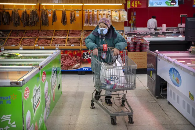 A woman wears a face mask as she shops at a grocery store in Beijing, Saturday, February 1, 2020. (Photo by Mark Schiefelbein/AP Photo)