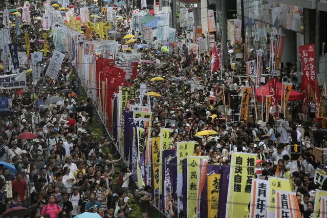 Hundreds o protesters march during an annual pro-democracy protest in Hong Kong, Friday, July 1, 2016. A Hong Kong bookseller who was to lead the southern Chinese city's annual pro-democracy protest march on Friday dropped out at the last minute, saying he felt “gravely threatened”. Organizers of the protest, which kicked off at downtown Victoria Park with tens of thousands in attendance, had invited Lam Wing-kee. (Photo by Vincent Yu/AP Photo)