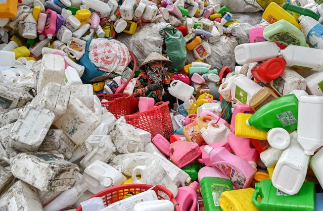 A worker sorts through plastic waste at a recycling site on the outskirts in Hanoi on September 17, 2024. (Photo by Nhac Nguyen/AFP Photo)