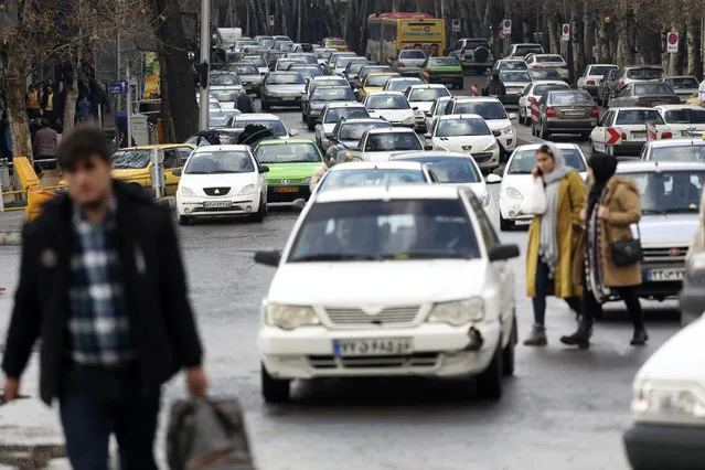 Cars drive as pedestrians walk in Tajrish square in northern Tehran, Iran, Thursday, January 9, 2020. (Photo by Vahid Salemi/AP Photo)