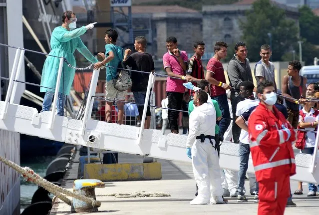 Migrants disembark from the Italian Coast Guard vessel “Diciotti” in the Sicilian harbour of Palermo, Italy, August 20, 2015. (Photo by Guglielmo Mangiapane/Reuters)