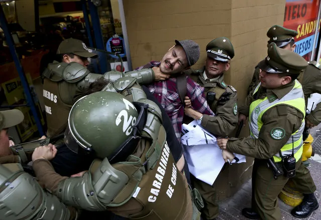 In this Thursday, August 17, 2017 photo, a man is detained by national police outside the Argentina consulate during a protest demanding information on the whereabouts of missing activist Santiago Maldonado, in Santiago, Chile. Maldonado's family says he went missing Aug. 1, when he was taking part in a protest supporting the land claims by the indigenous Mapuche community. They say border police detained him when he was blocking a road with other protesters in Chubut province, about 1,100 miles (1,800 kilometers) southeast of Argentina's capital. (Photo by Esteban Felix/AP Photo)