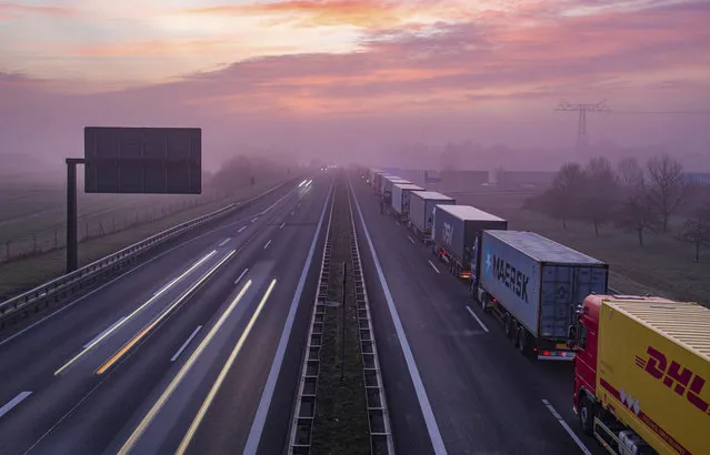 Trucks are jammed in the early morning on Autobahn 12 in front of the German-Polish border crossing near Frankfurt (Oder), Germany, Wednesday, March 18, 2020. In order to make it more difficult for the corona virus to spread, Poland had reintroduced controls at the border crossings to Germany. (Photo by Patrick Pleul/dpa via AP Photo)