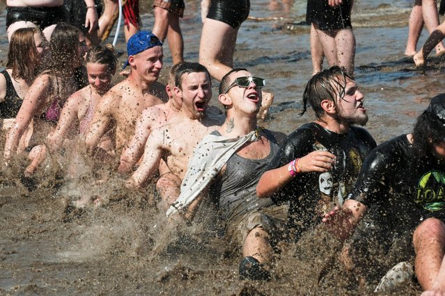 Festival-goers take part in the traditional mud bath on the last day of the 22nd Przystanek Woodstock (lit. Woodstock Bus Stop) Music Festival on the Odra River in Kostrzyn, Poland, 16 July 2016. The Woodstock Festival is one of the biggest open-air festivals in Europe. (Photo by Lech Muszynski/EPA)