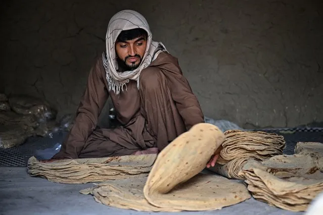 A man stacks flatbread in a bread factory in Kandahar on July 28, 2022. (Photo by Lillian Suwanrumpha/AFP Photo)