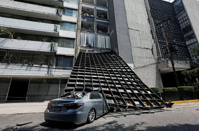 A damaged car is seen outside a building after an earthquake in Mexico City, Tuesday, September 19, 2017. (Photo by Claudia Daut/Reuters)