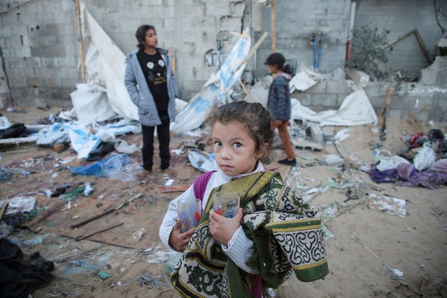 A Palestinian girl holds glasses in her hands as she stands amidst the damage at a tent camp sheltering displaced people, following an Israeli strike, amid the Israel-Hamas conflict, in Al-Mawasi area, in Khan Younis, southern Gaza Strip on December 18, 2024. (Photo by Hatem Khaled/Reuters)