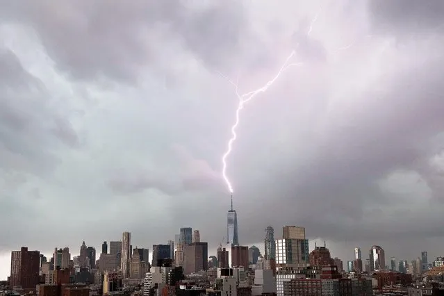 A bolt of lightning hits the spire of One World Trade Center as dark thunderstorm clouds pass over the Manhattan skyline before a storm dumps rain and hail in New York City on Saturday, November 13, 2021. (Photo by John Angelillo/UPI/Rex Features/Shutterstock)
