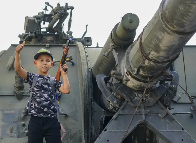 Schoolboy Lev Morilyi gripped his toy AK-47 on a destroyed Russian tank on August 20, 2022 as he declared: “We will defeat Putin“. Crfowds gather in central Kyiv to look at a display of destroyed Russian tanks that have been placed on the Citys main street ahead oif the countries national day on Wednesday. (Photo by Chris Eades/The Sun)
