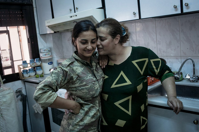 Jin, left, a YPJ soldier, shares an intimate moment with her mother, Amina, at their home in Girke Lege, Rojava, Syria on August 18, 2014. Even though she lives at a YPJ base near by her home, Jin had not seen her mother in over a month because of the highly demanding YPJ military schedule. (Photo by Erin Trieb/NBC News)