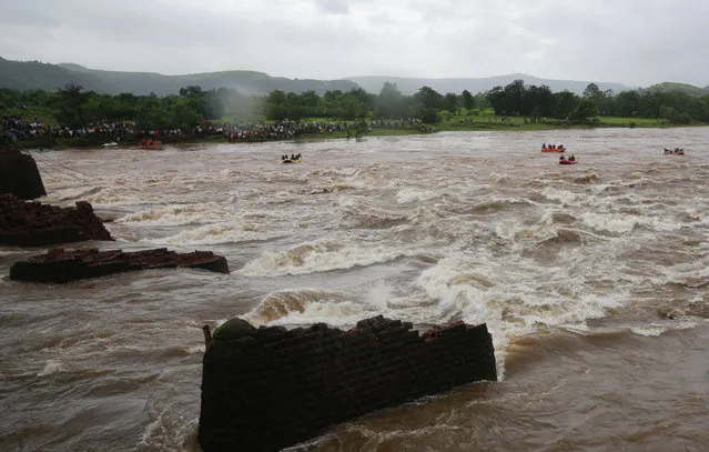Rescue workers search the flooded River Savitri after an old bridge collapsed in Mahad, western Maharashtra state, India, Wednesday, August 3, 2016. Two buses plunged into the river after the old bridge collapsed, an official said. (Photo by Rafiq Maqbool/AP Photo)