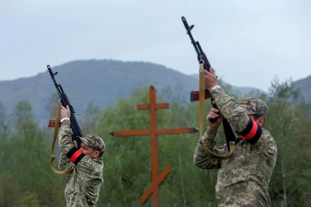 Ukrainian service members shoot in the air during a funeral ceremony for their brother-in-arm Armen Petrosian, 50, who was recently killed in a fight against Russian troops during the liberation of Kharkiv region, amid Russia's attack on Ukraine, in Perechyn, Zakarpattia region, Ukraine on September 25, 2022. (Photo by Serhii Hudak/Reuters)