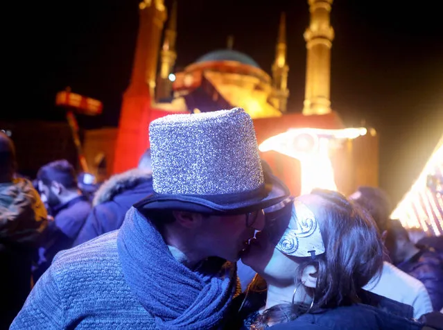 Lebanese ant-corruption protesters share a kiss to celebrate New Year's eve in Beirut Martyr’s Square on December 31, 2019. (Photo by Patrick Baz/AFP Photo)