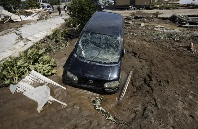 A damaged vehicle is seen at a residential area flooded by the Kinugawa river, caused by typhoon Etau, in Joso, Ibaraki prefecture, Japan, September 11, 2015. (Photo by Issei Kato/Reuters)