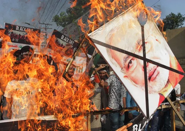 Activists of Pakistan Youth Forum burn pictures if Indian Prime Minister Narendra Modi during rally on the occasion Indian Independence Day in Lahore, Pakistan, Monday, August 15, 2016. India gained its independence from British colonial rule on this day in 1947. (Photo by K.M. Chaudary/AP Photo)