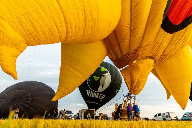 Crews inflate hot air balloons during the 39th annual New Jersey Lottery Festival of Ballooning at Solberg Airport Friday, July 29, 2022, in Readington, N.J. The festival, which runs through Sunday, July 31, will feature as many as 100 balloons. (Photo by Julia Nikhinson/AP Photo)