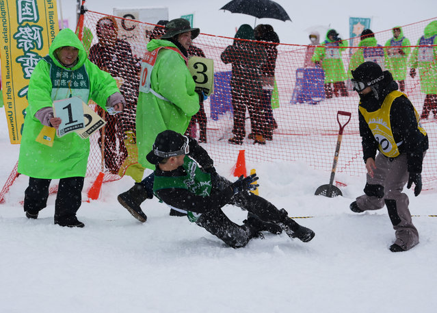 A man falls while throwing a snowball at the 35th Koide International Snowball Fight in Uonuma, Niigata Prefecture, Japan, on February 9, 2025. (Photo by Tom Bateman/Reuters)
