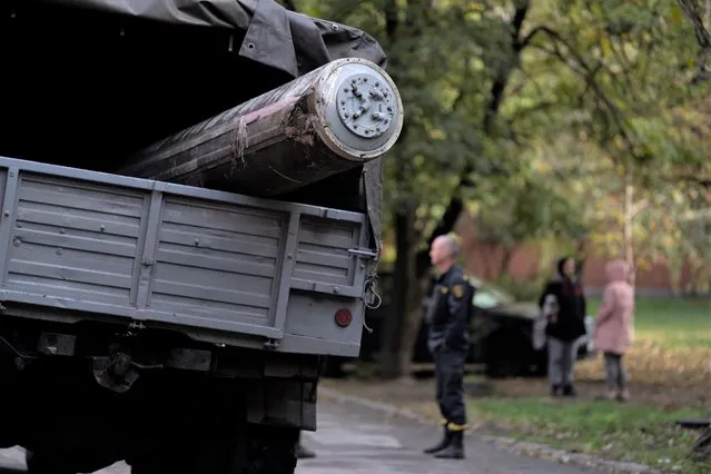 Ukrainian emergency service member stands next to a truck that carries the remains of a missile after a Russian attack in Zaporizhzhia, Ukraine, Friday, October 21, 2022. (Photo by Leo Correa/AP Photo)
