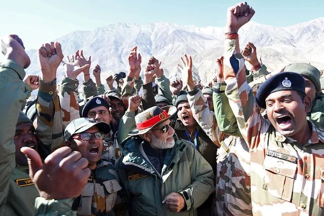 This handout photograph taken on October 24, 2022 and released by the Indian Press Information Bureau (PIB) shows India's Prime Minister Narendra Modi (C) attending the celebrations with the members of Indian armed forces on the occasion of Diwali, the Hindu festival of lights, at Kargil. (Photo by PIB/AFP Photo)