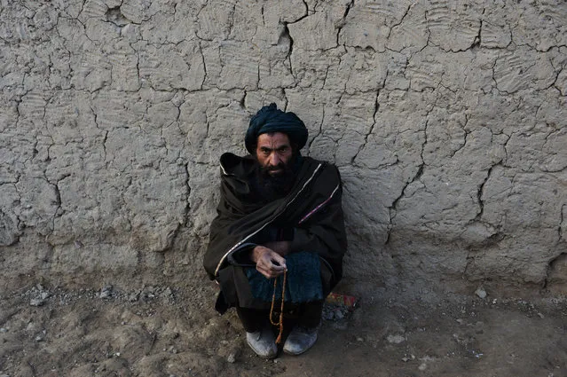 An Internally displaced an Afghan man prays as he sit at a refugee camp in Kabul on November 19, 2017. (Photo by Noorullah Shirzada/AFP Photo)