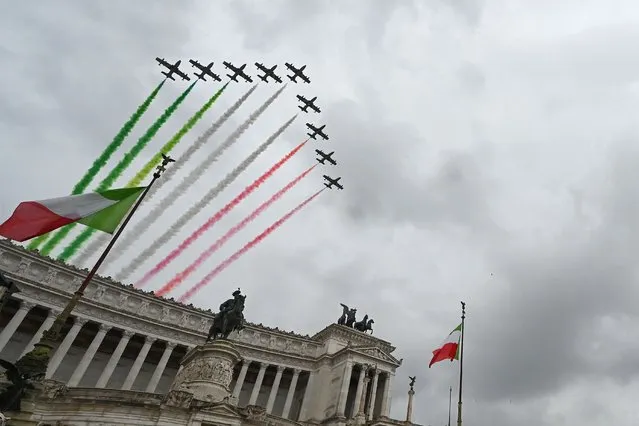 Planes of the Italian Air Force aerobatic unit Frecce Tricolori (Tricolor Arrows) spread smoke with the colors of the Italian flag as they fly over the Altare della Patria monument Rome on November 4, 2022 as part of celebrations of National Unity and Armed Forces Day, marking the end of the World War I in Italy. (Photo by Andreas Solaro/AFP Photo)