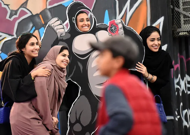 Saudi girls pose for a group picture as one stands behind a frame depicting King Kong, while attending the first ever Comic- Con Arabia event held in the capital Riyadh on November 25, 2017. (Photo by Fayez Nureldine/AFP Photo)