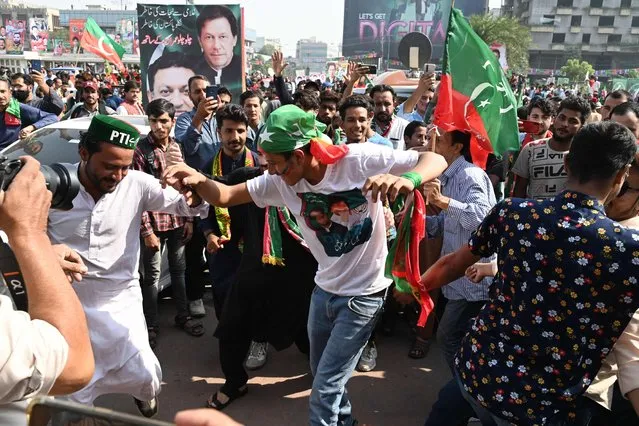 Activists and supporters of opposition party Pakistan Tehreek-e-Insaf (PTI) dance before the start of an anti-government long march towards Islamabad to demand early elections, in Lahore on October 28, 2022. Former Pakistan prime minister Imran Khan launched a so-called “long march” Friday on the capital Islamabad to demand early elections, piling pressure on a government already in crisis. (Photo by Arif Ali/AFP Photo)
